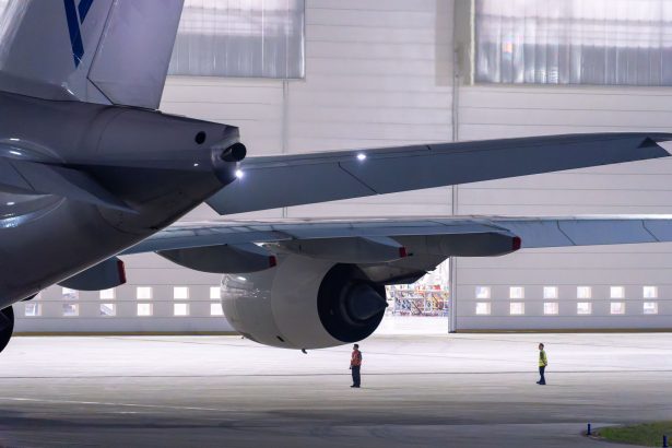 Equipe de manutenção inspeciona uma aeronave dentro de um hangar.