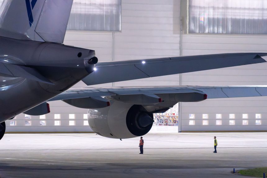 Equipe de manutenção inspeciona uma aeronave dentro de um hangar.