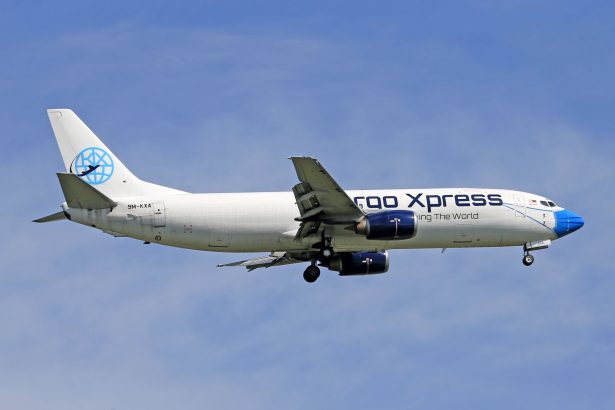 Avião cargueiro voando contra um céu azul.